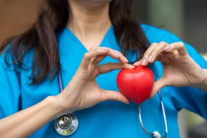 Blog 2 Female Cardiovascular Disease Doctor Or Cardiologist With Stethoscope Holding Red